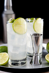 Gin Fizz cocktail with lime on black background