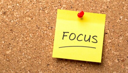 Motivational focus note on corkboard home office visual reminder organized workspace close-up productivity concept