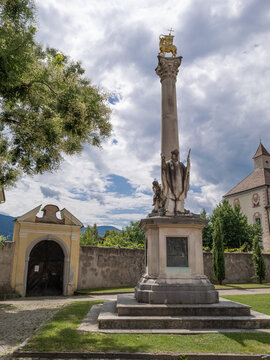 Millennial Column in Brixen, 1909 monument with lamb -city emblem- and statue of Bishop Zachariah, Italy