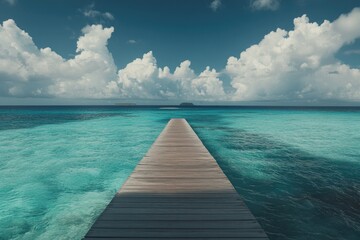 Naklejka premium Tranquil wooden pier stretches into turquoise water, with distant islands and a vast sky