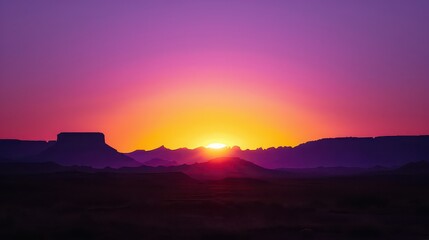 A vibrant sunset over a silhouetted mountain range with a pink and orange gradient sky above it