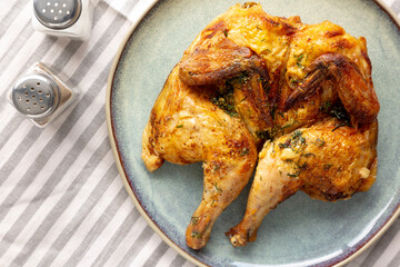 Homemade Grilled Chicken Tabaka on a Plate, top view. Flat lay, overhead, from above.