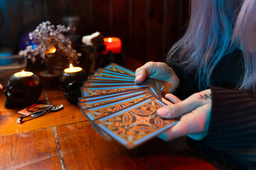 Fortune teller reading tarot cards by candlelight in mystical atmosphere
