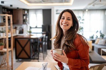 Happy architect drinking coffee in modern home office