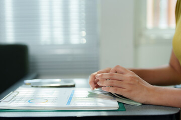 Fototapeta premium Accountant counting dollar banknotes near financial report with charts and graphs