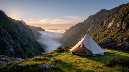 A camping tent set high in the mountains, surrounded by misty peaks and lush green valleys. The early morning light casts a soft golden glow on the tent