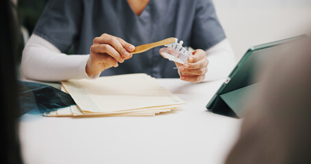 Hands, dentist and model explain with brush for oral hygiene, teeth whitening and cleaning for...
