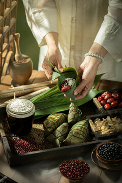 Asian women wrapping rice dumplings, food preparation for Dragon Boat Festival(zongzi)