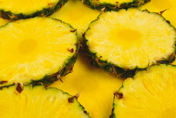 Pineapple juicy yellow slices background. Top view.