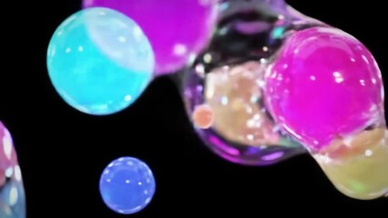 Vibrant bubbles of blue, turquoise, and purple drift gracefully through a dark setting, reflecting light in an enchanting manner that captivates the viewer’s attention.