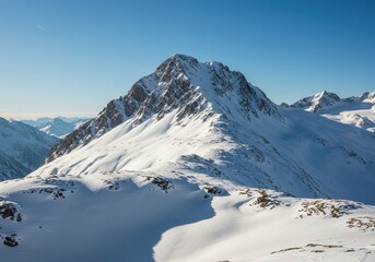 Snow covered mountain peak under a clear blue sky on a bright winter day