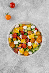 Sweet corn salad with arugula, tomatoes, cucumber, red onion and mozzarella. Healthy food. Top view.