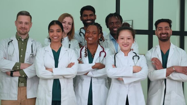 Diverse medical team standing side by side in hospital hallway, wearing white lab coats, representing collaborative healthcare professionals working together with confidence