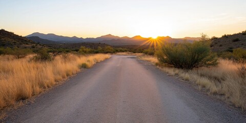 A road in the desert with a sun shining on it. The sun is setting in the background
