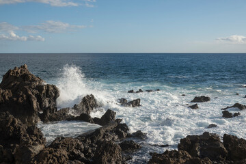 Waves Crashing Against black Lava Rocks on a Tropical Coast, water splashing at canary island Tenerife