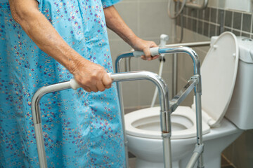 Asian elderly woman patient use walker and toilet bathroom handle security in nursing hospital,...