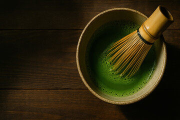 Matcha tea bowl with bamboo whisk on wooden table, creating calm and traditional tea preparation scene