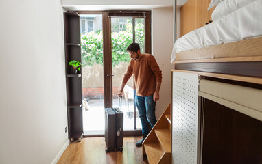 Modern hostel with cozy minimalist dorms, wooden capsule beds, and peaceful courtyard. Men chatting...