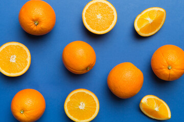 Fruit pattern of fresh orange slices on colored background. Top view. Copy Space. creative summer concept. Half of citrus in minimal flat lay