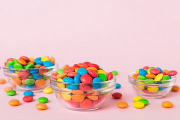 Multicolored candies in a bowl on a colored background. birthday and holiday concept. Top view with copy space