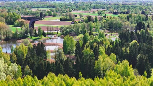 The Striking, Canoe-shaped Kirkilai Observation Tower Rises Above the Karst Lakes and Forests of Biržai Regional Park in Lithuania - Aerial Drone Shot
