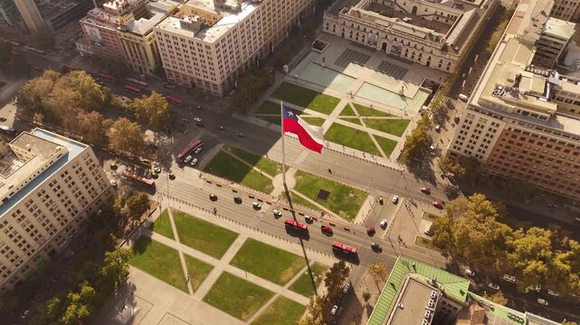 Patriotic flag of Chile in center of de Chile at sunset time. Aerial top down shot. Trees at famous avenue with cars.Traffic scene with tram and cars.