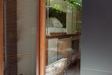 Modern hostel with cozy minimalist dorms, wooden capsule beds, and peaceful courtyard. Men chatting...