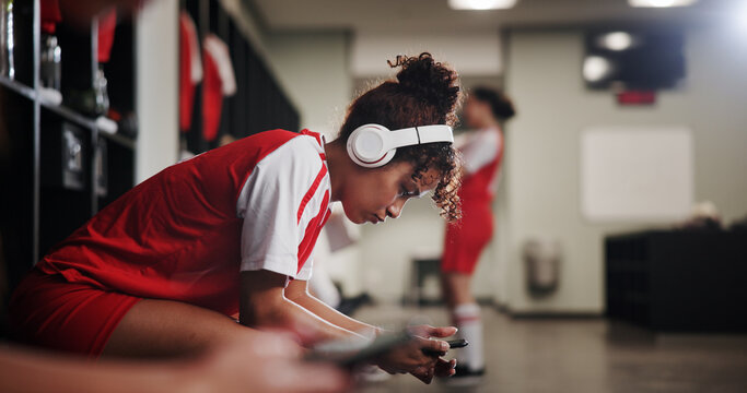 Girl, soccer player and headphones in locker room for music, sports and inspiration for game. Profile, woman and athlete with streaming, listen and prepare with audio subscription for football match