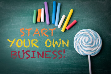 Start Your Own Business Message on Chalkboard with Colorful Chalk and Candy