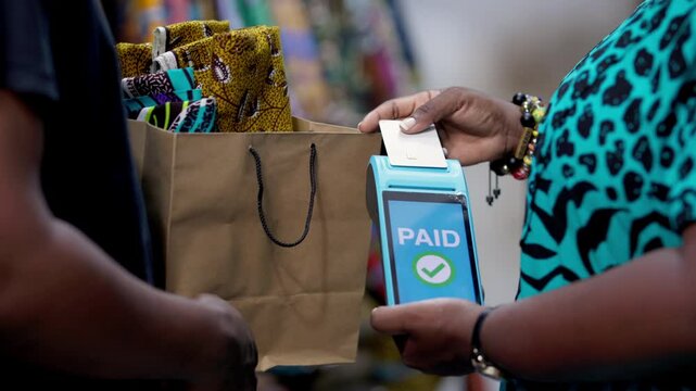 Customer makes cashless payment with credit card using the Point of Sale (POS) terminal for African Print, Ankara fabric and textiles cloth.