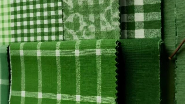 Various green fabrics and a color palette with a sprig of leaves create a harmonious composition