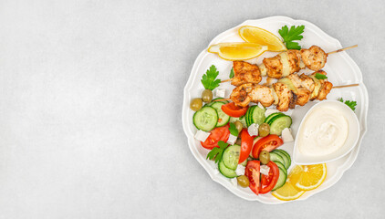 Grilled chicken kebab with fresh vegetable salad on white background, top view, copy space