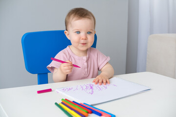 little girl draws with colored markers. Toddler development
