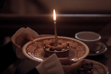 birthday cake with one candle, a girl makes a wish on her birthday