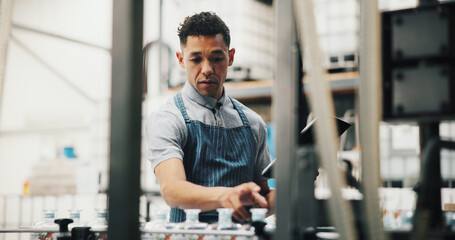 Distillery, inspection and man in factory on tablet for alcohol production, manufacturing and checklist. Brewery, industrial business and person on tech for fermentation, quality control and storage