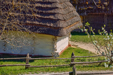 traditional Ukrainian hut with a thatched roof and a wooden fence