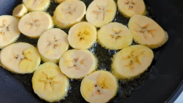 Sliced plantain during frying process 