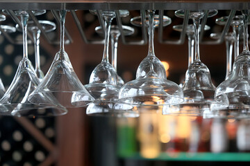clean glass wine glasses hanging, background on the bar counter in the restaurant, abstract view of the bar