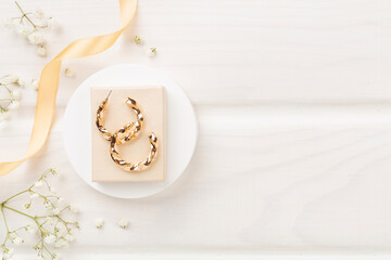 Elegant golden jewelry with decoration on wooden background, top view