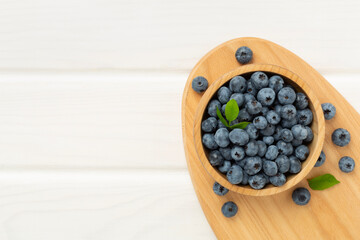 Bowl with fresh bright blueberries on wooden background,top view