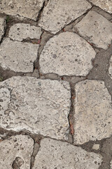 Vertical Top-Down Texture Of An Ancient Pavement Made From Large, Irregularly Shaped Light Grey...