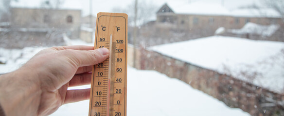Thermometer at winter snow background. Bad weather