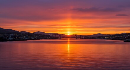 Obraz premium Fiery Sunset over Coastal Bridge and Town