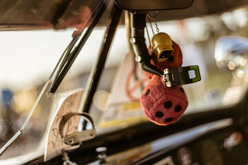 Fuzzy dice hanging from rearview mirror in classic car