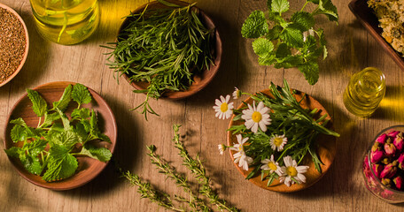 Composition of fresh chrysanthemums placed on a wooden plate, dried basil and rosemary placed on...
