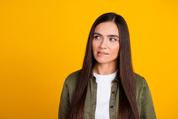 Fototapeta premium Young woman with brunette hair standing against a bright yellow background showcasing casual and stylish fashion