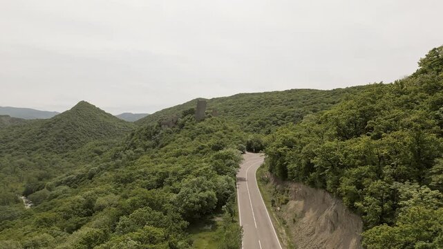 Aerial view car drive on asphalt curvy road by Ujarma Fortress &ndash; Ancient Hilltop Royal Citadel and Strategic Stronghold of the Iberian Kings in Kakheti, Georgia