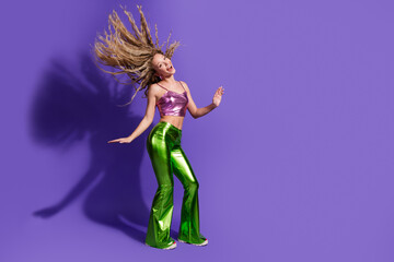 Full body portrait of nice young girl dancing flying hair empty space wear shiny outfit isolated on purple color background