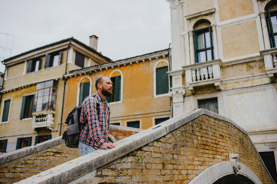 Fototapeta A man on the narrow streets of Venice