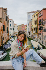 A young woman walks through Venice, on the bridge